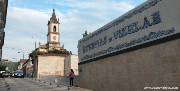 Cartel de las Termas de Vizela con iglesia detrás